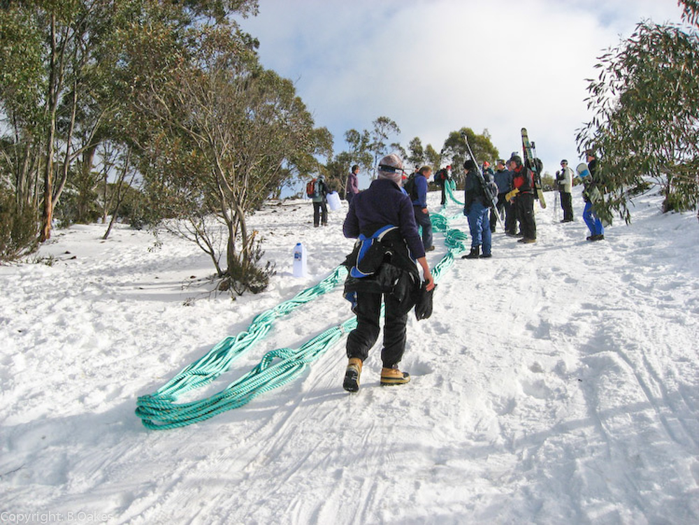 image of STSA volunteers bringing a new tow rope up the mountain during winter for an emergency repair